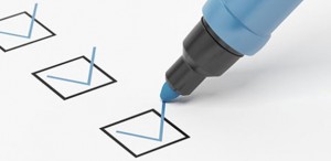 A blue marker checking boxes on a piece of paper